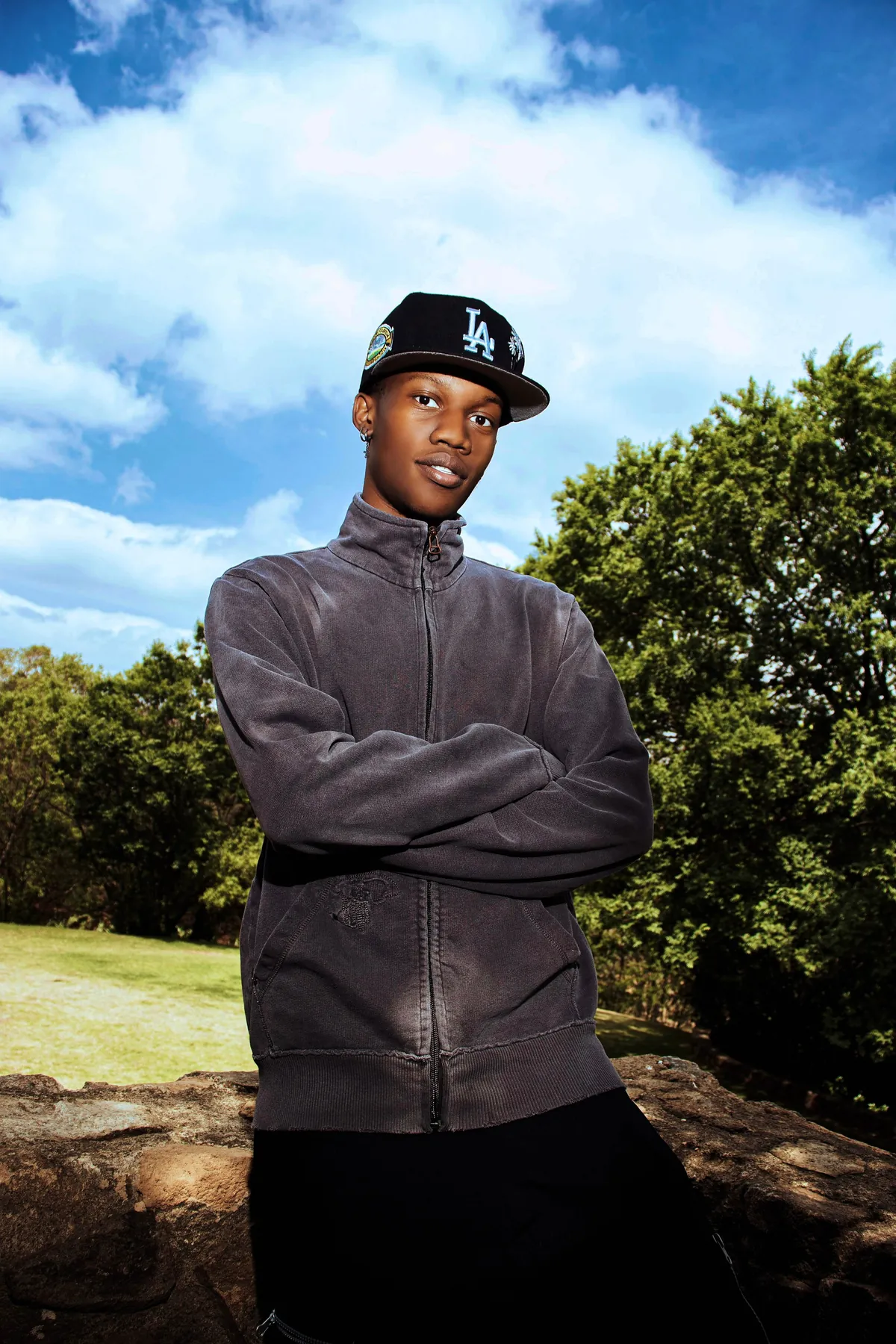 Kgosi outdoors, arms folded