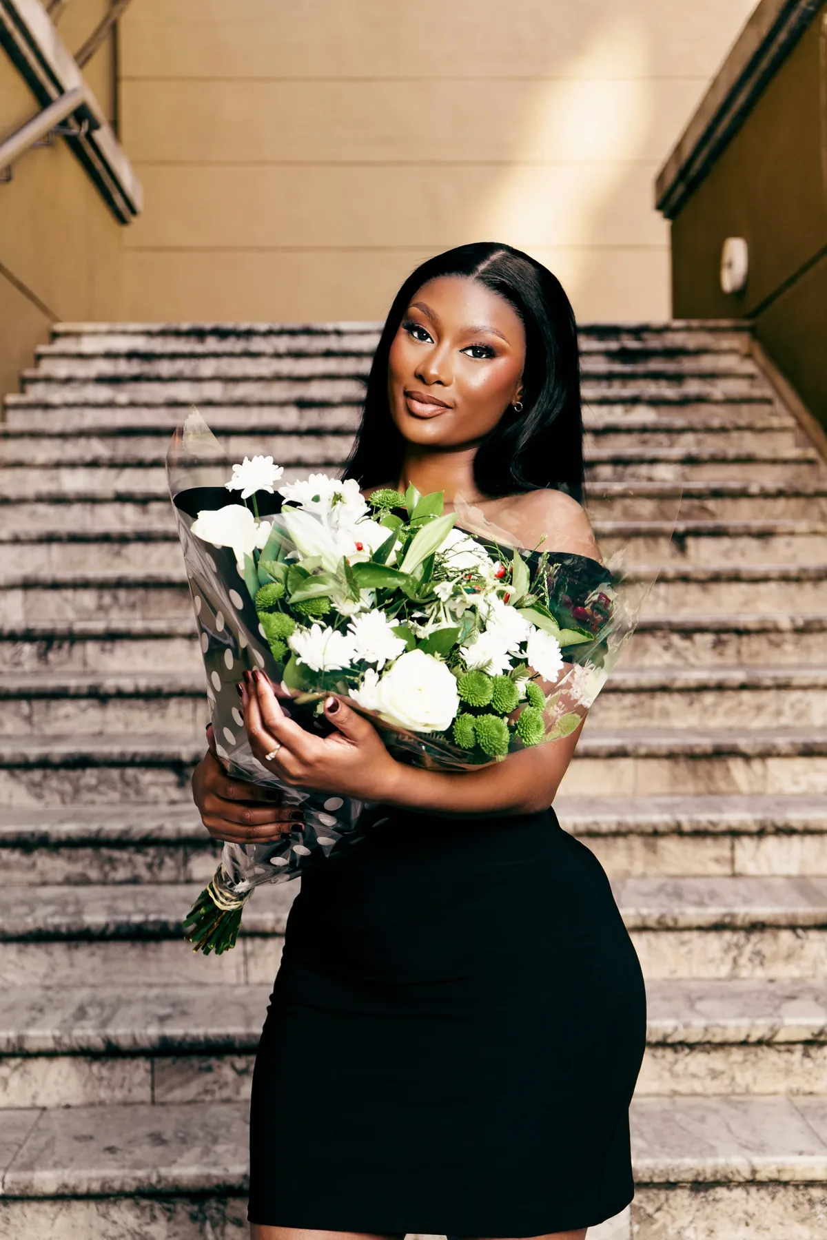 Portrait with bouquet on a staircase